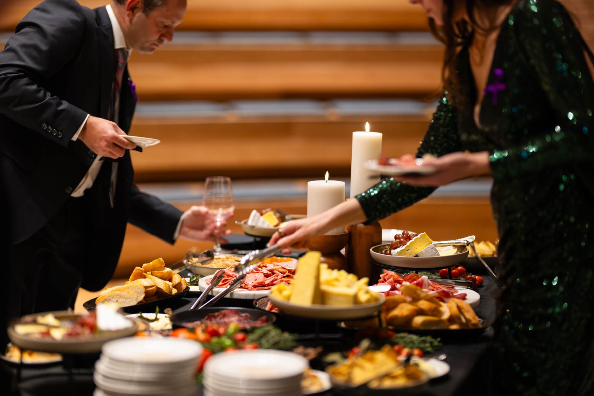 Guests serving from the candlelit grazing table